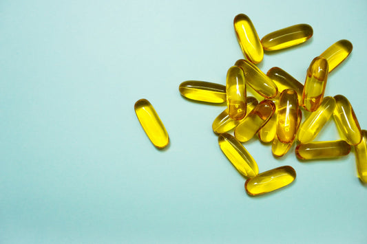 Cápsulas softgel amarelas de vitamina D3 sobre fundo azul