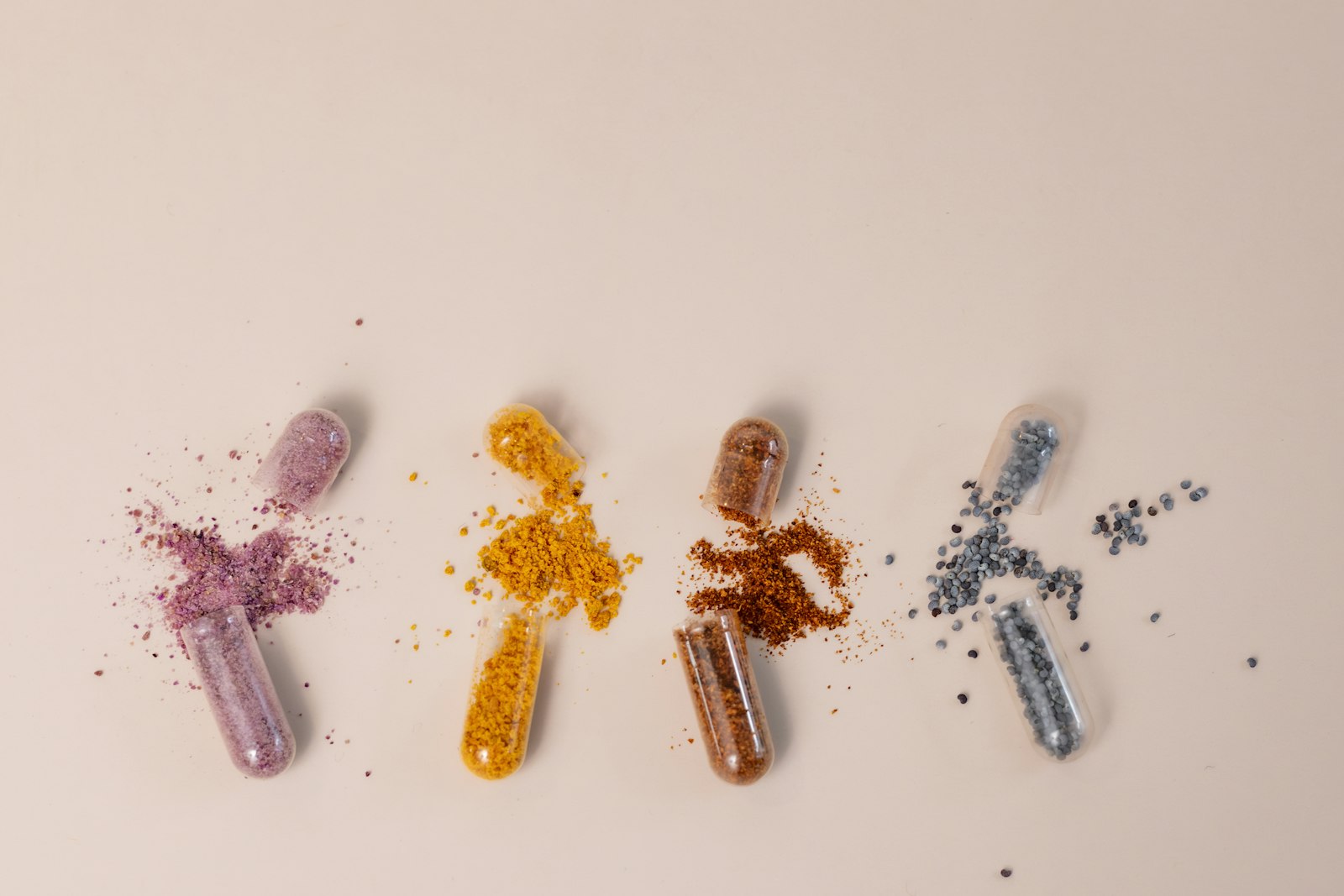 Cápsulas coloridas de multivitamínico abertas sobre fundo claro