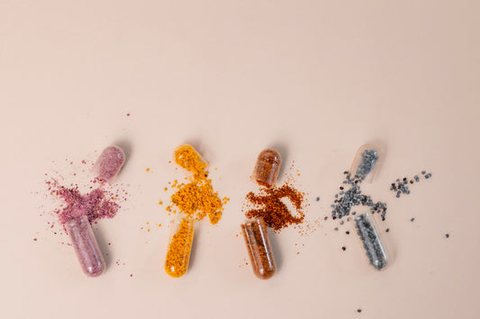 Cápsulas coloridas de multivitamínico abertas sobre fundo claro